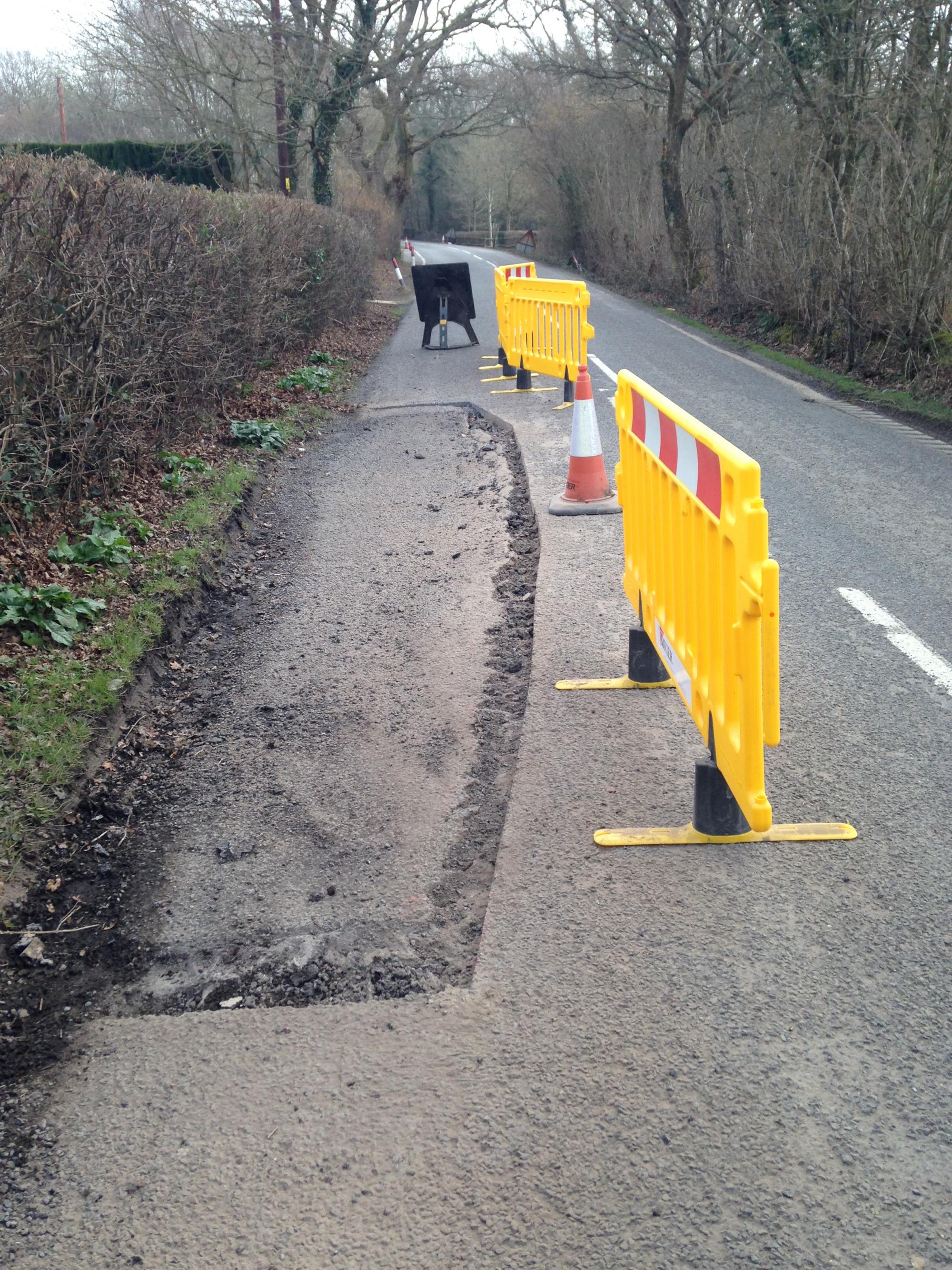 Damaged section of road cut out to create good surface for repair to bond to.